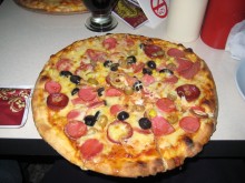 A pizza pockmarked with olives.